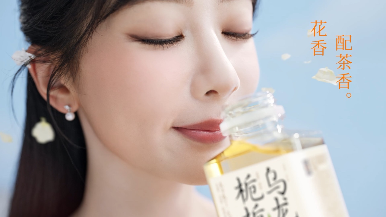 Yang Zi holding a Guozishule tea bottle in a bright outdoor campaign scene.